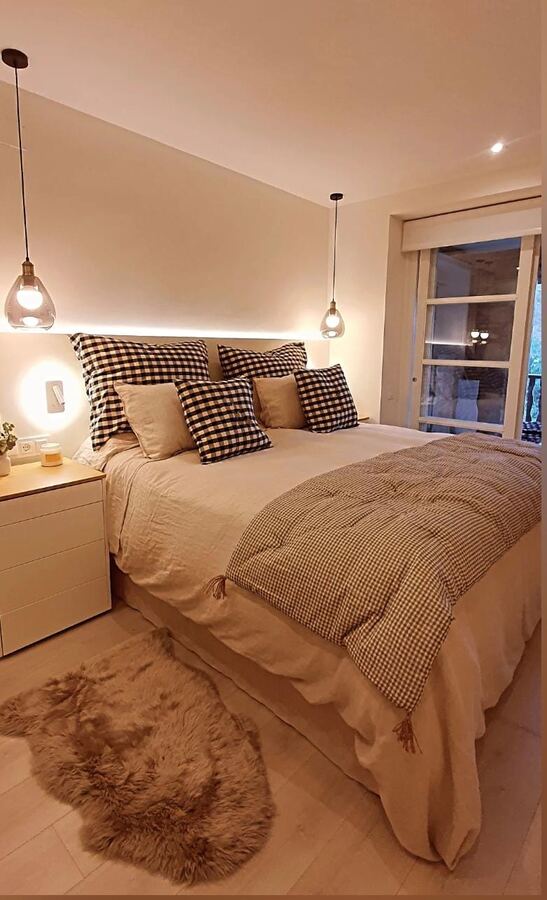 Dormitorio con vistas a la montaña y cojines de cuadros vichy
