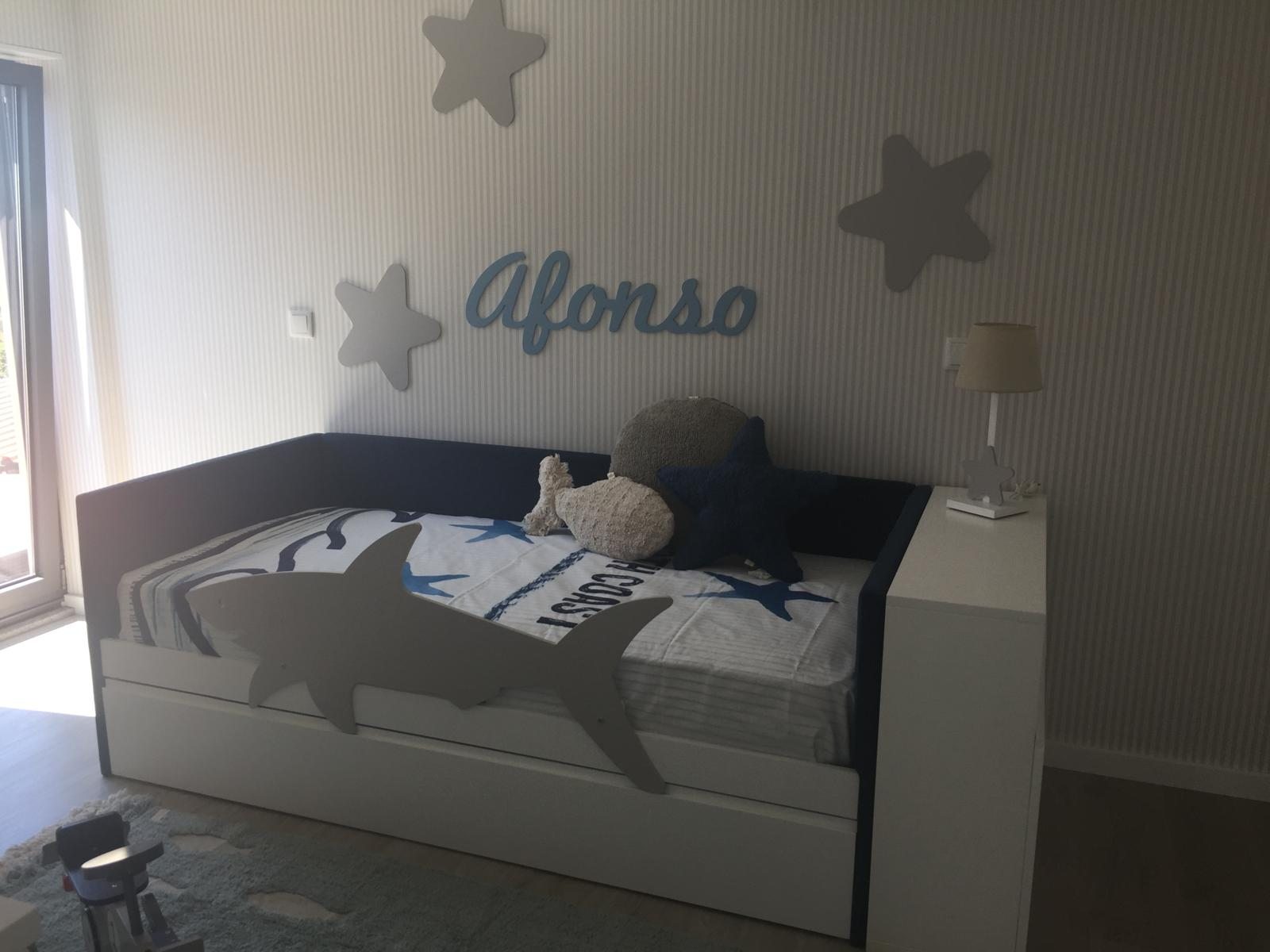 Detalle de la ropa de cama y la mesilla junto al cabecero