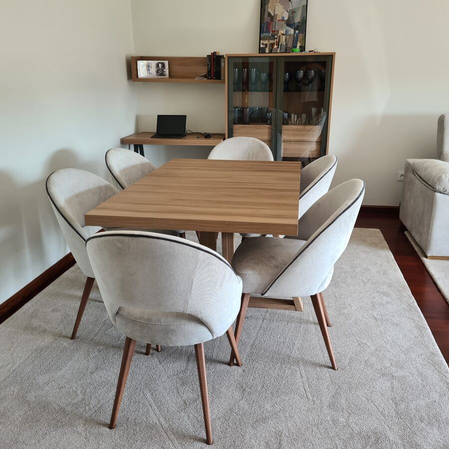 Salón comedor con mesa de madera maciza y sillas tapizadas